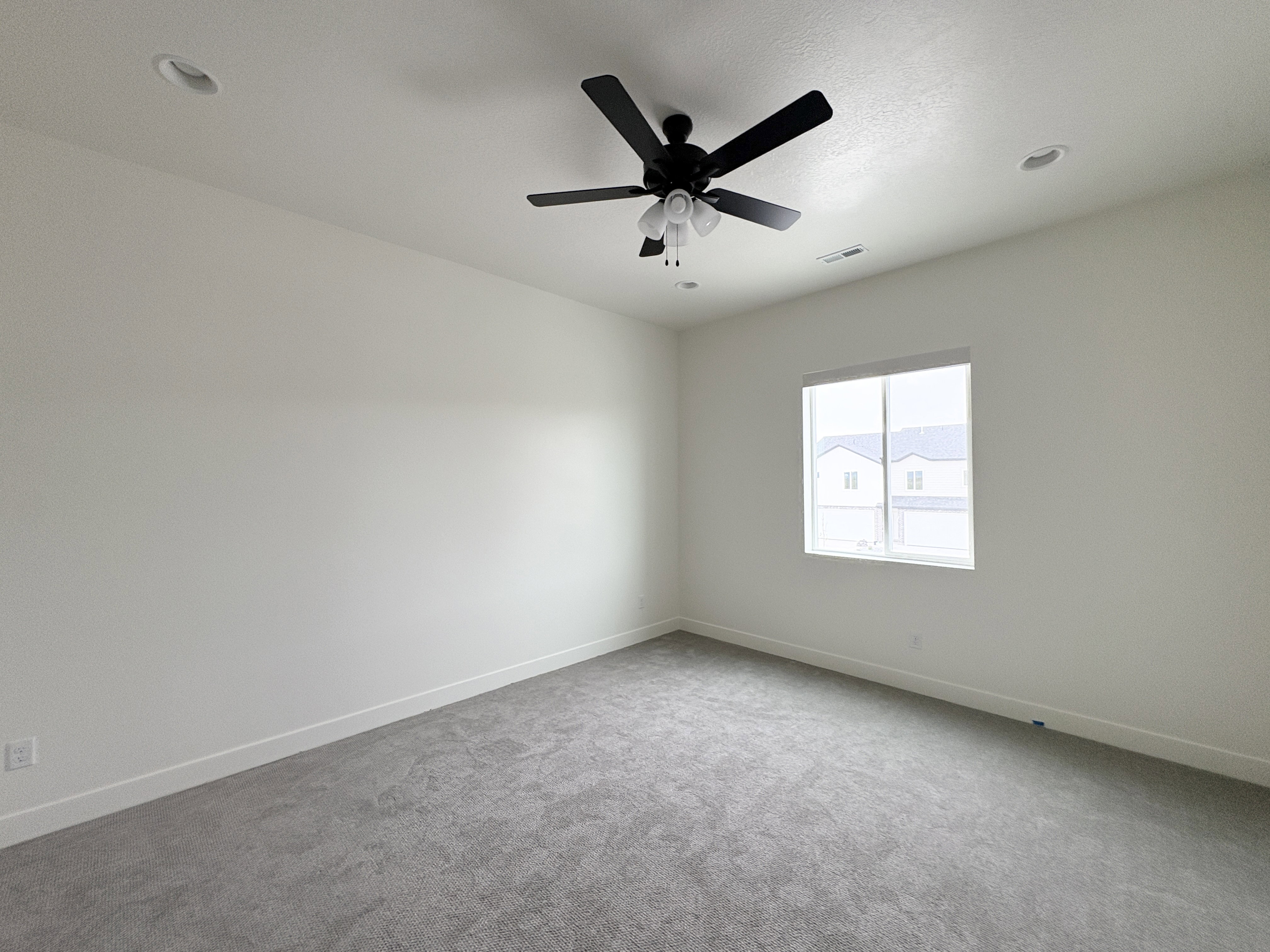 Carpeted spare room with baseboards and a ceiling fan
