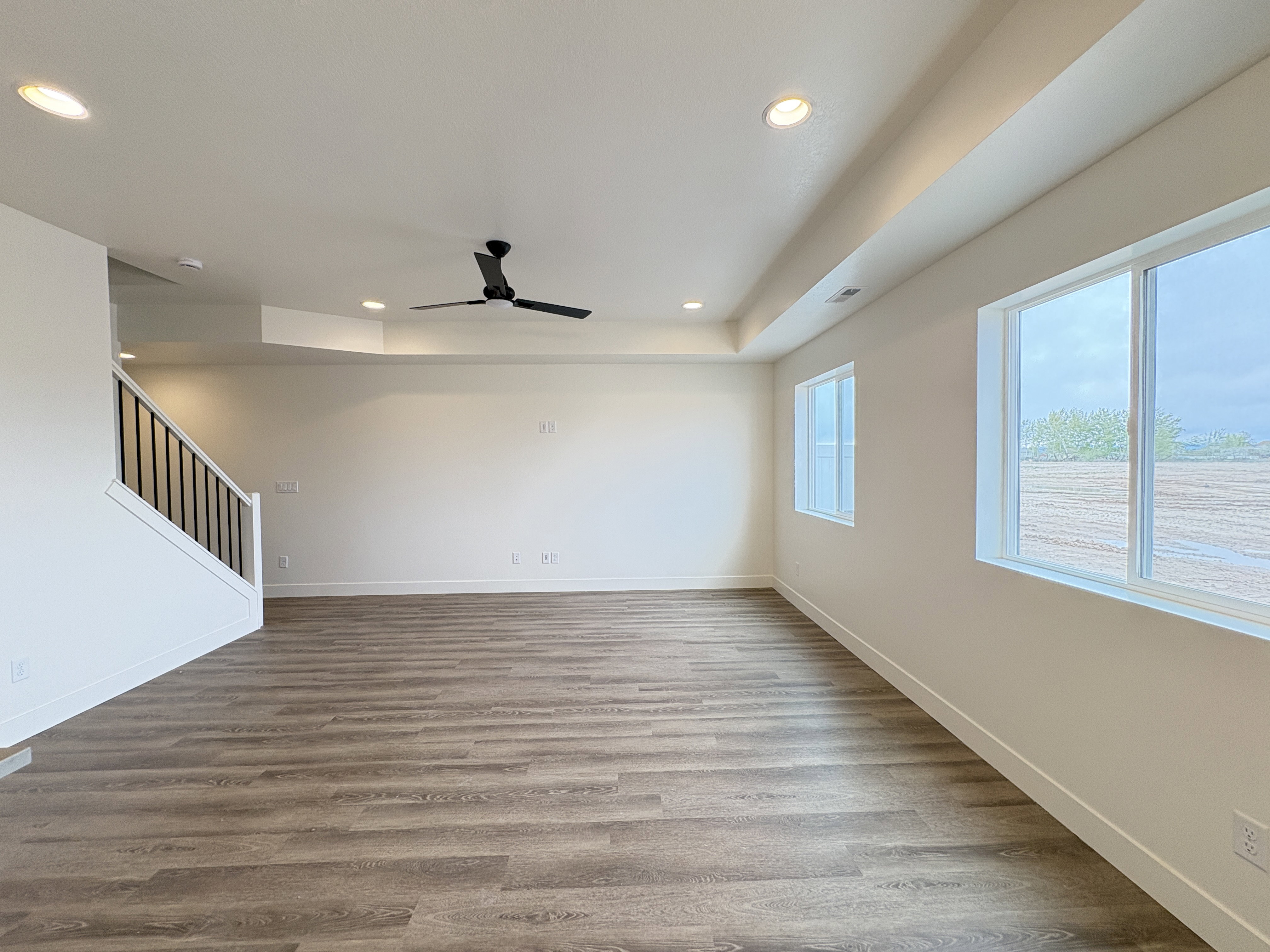 Spare room featuring light wood-style floors, a ceiling fan, and recessed lighting