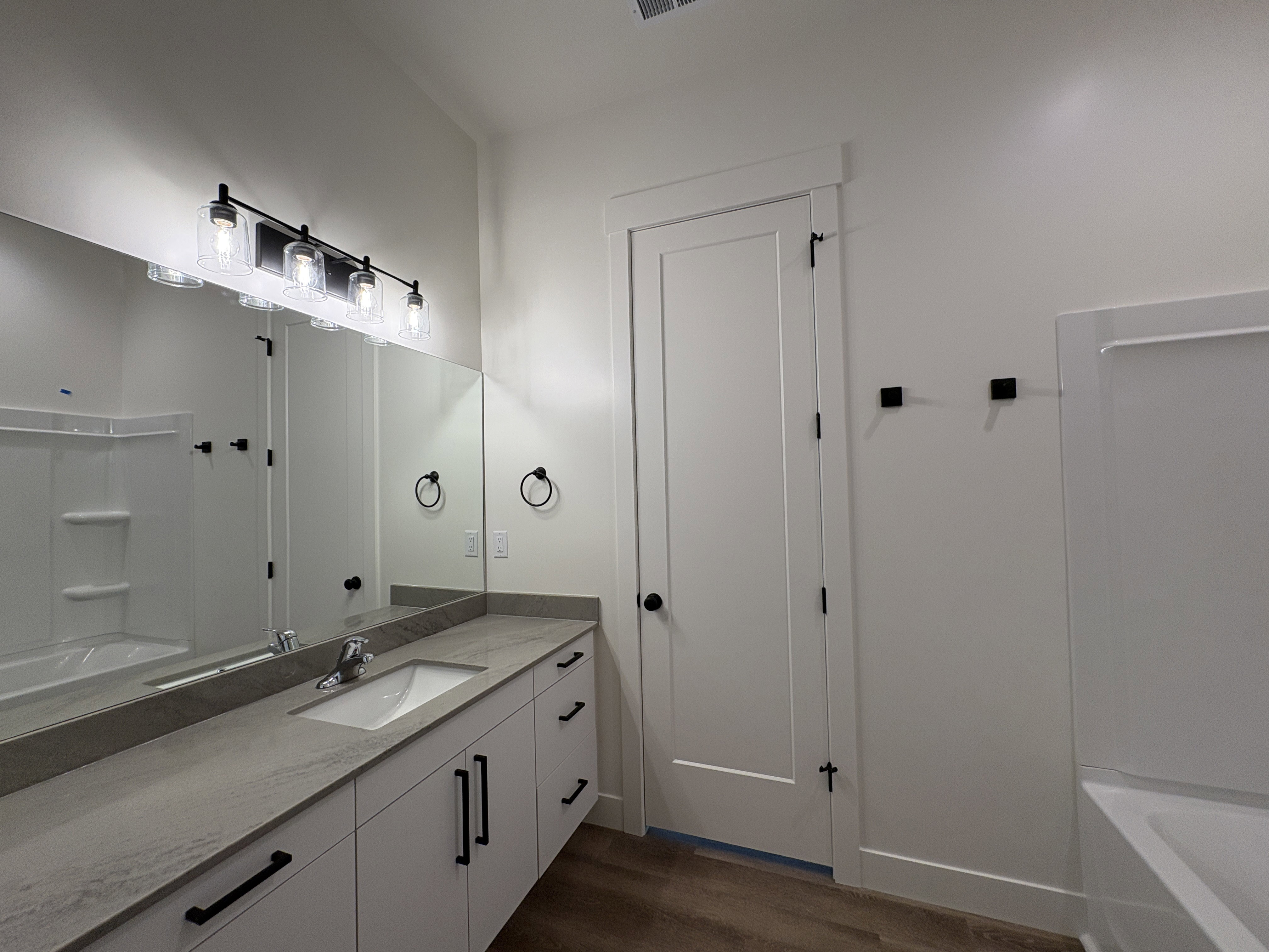Full bathroom featuring vanity, washtub / shower combination, and dark wood finished floors