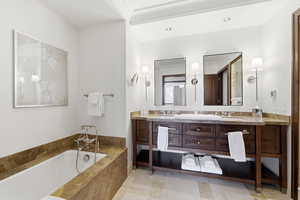 Bathroom featuring double vanity and a bath