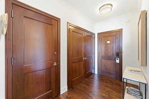 Entrance foyer featuring dark wood finished floors and crown molding