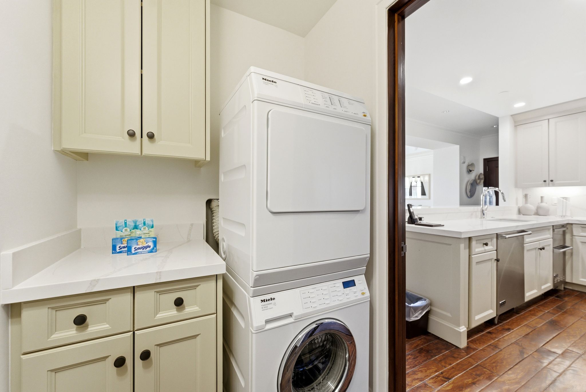 Laundry room with stacked washer / dryer, dark wood finished floors, and recessed lighting