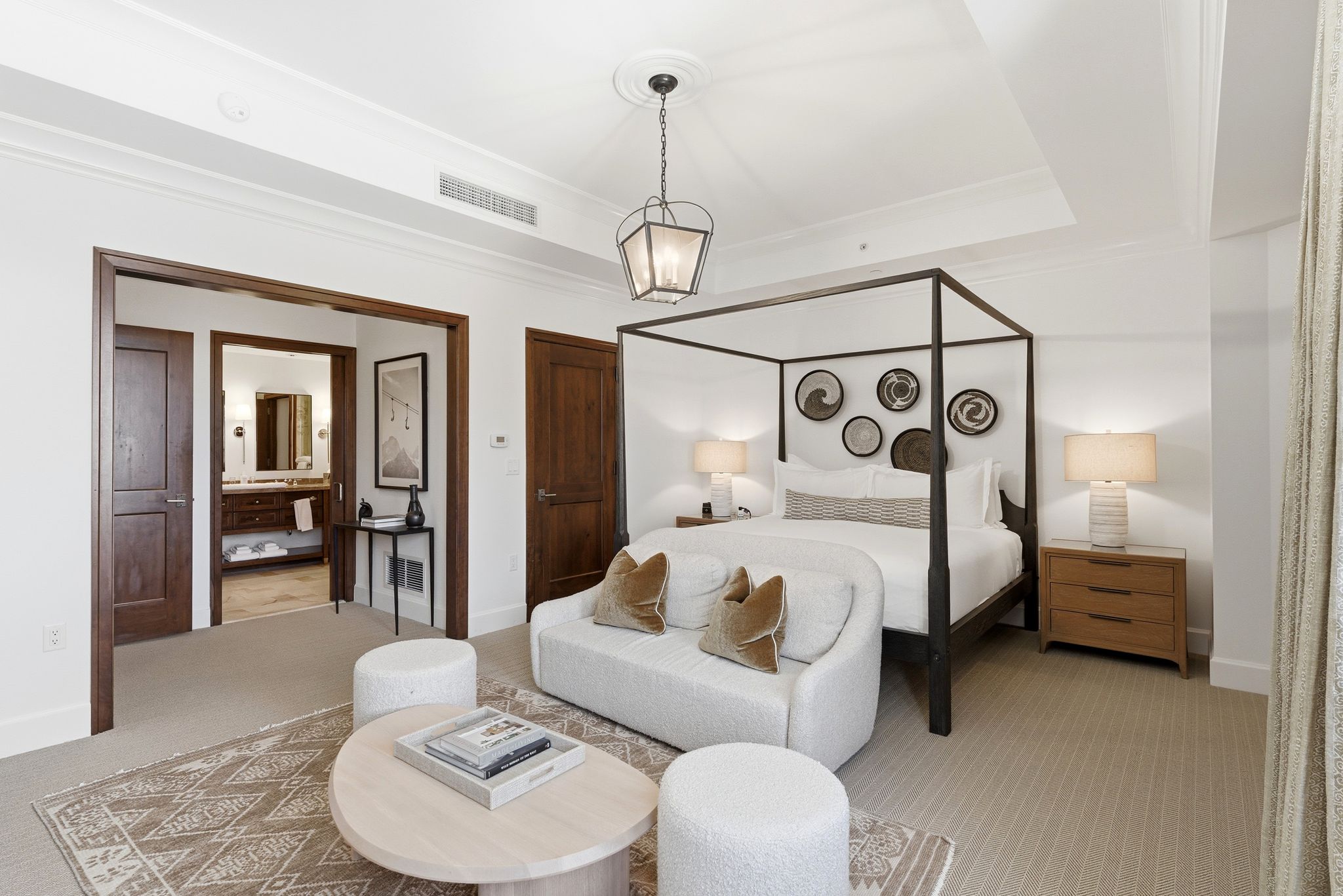 Bedroom with crown molding, carpet floors, a tray ceiling, connected bathroom, and suspended lighting