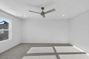Carpeted spare room featuring ceiling fan and recessed lighting