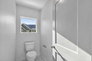 Bathroom with toilet and light marble finish flooring