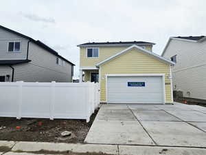 View of front facade featuring driveway and a garage