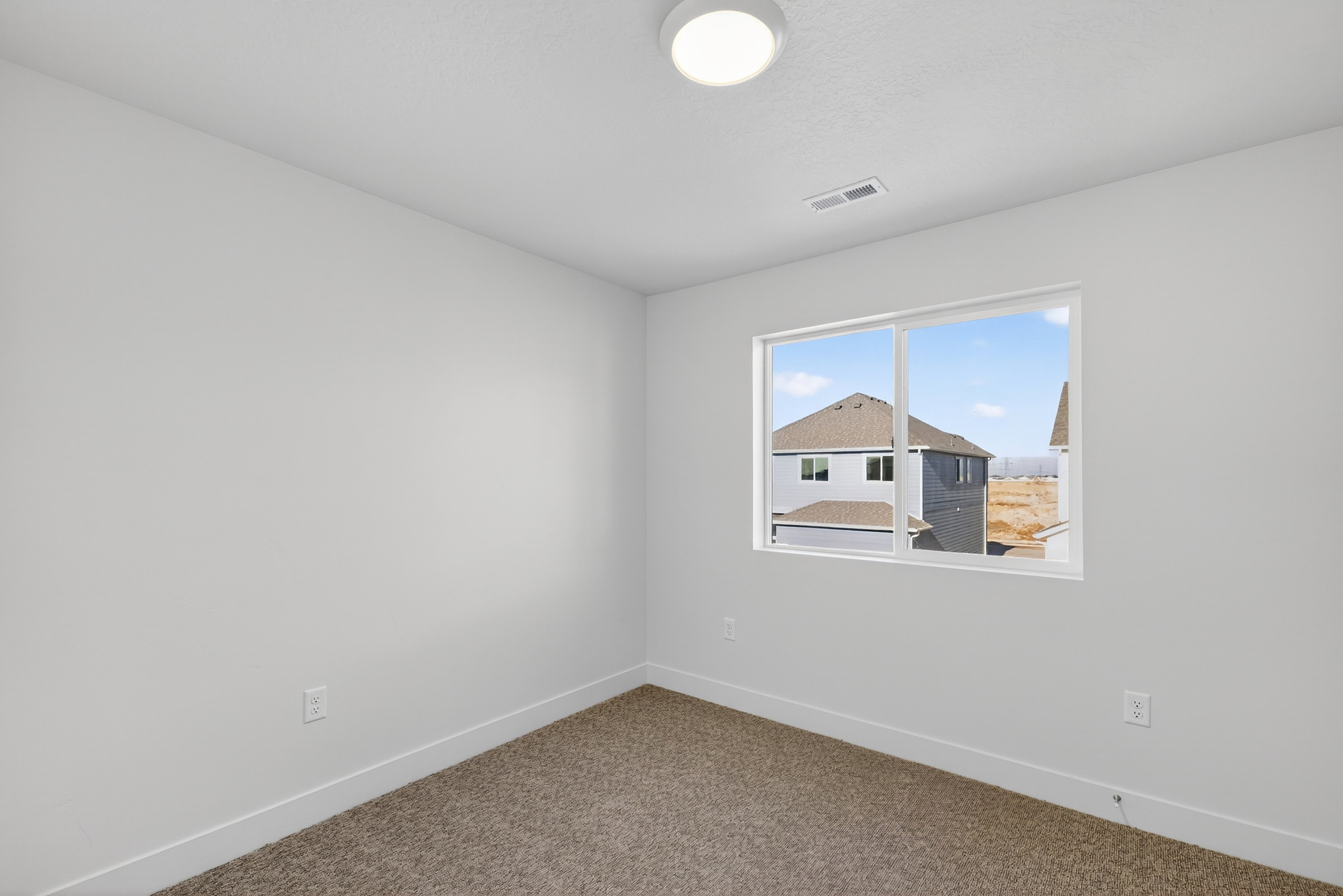 Bright room featuring neutral carpet flooring, white walls, and a large window with white trim