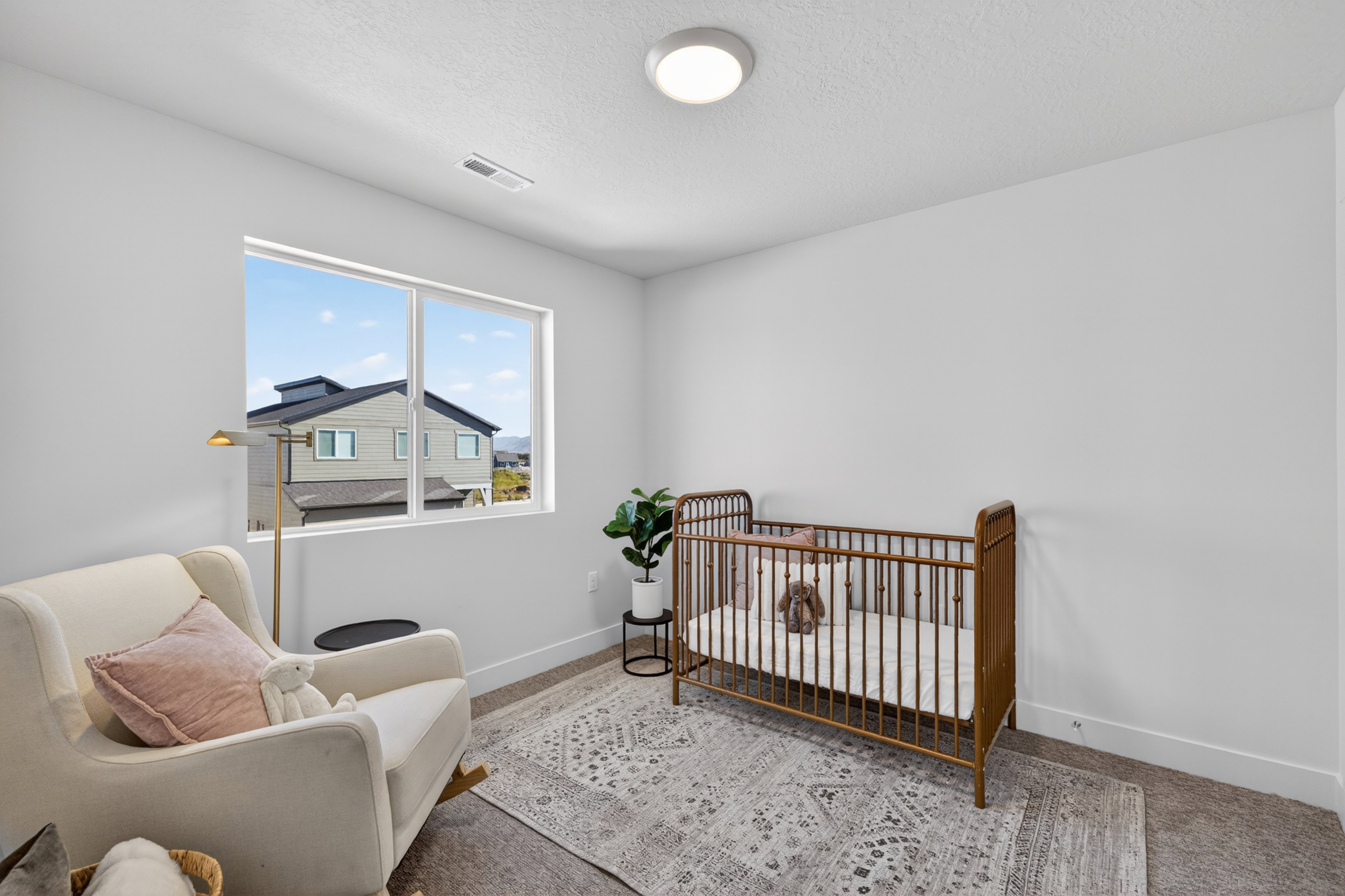 Bright room featuring a large window, neutral wall paint, and carpet flooring