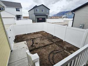 Fenced backyard with an attached garage and a mountain view