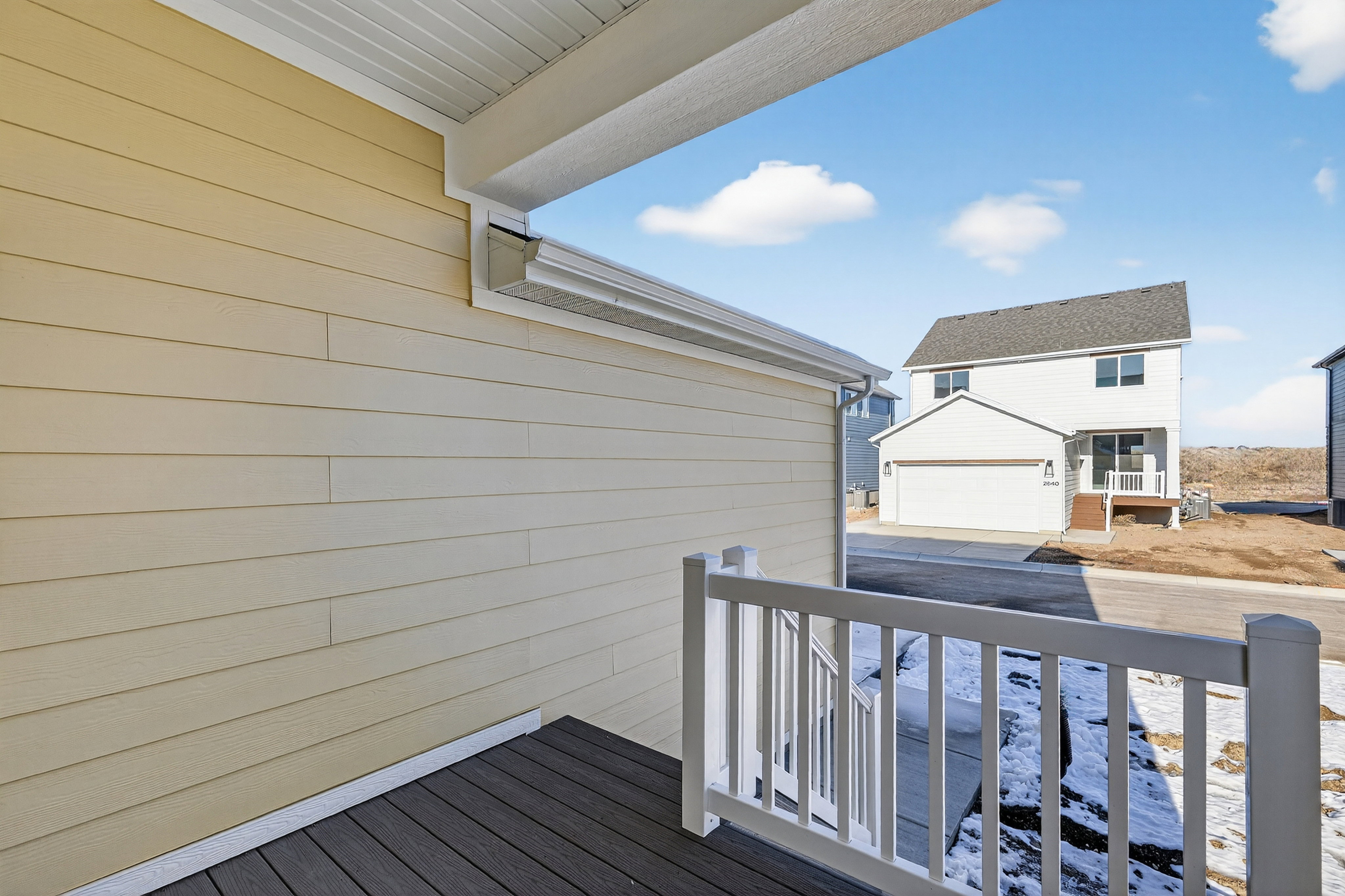 Outdoor decking with white railings and beige siding