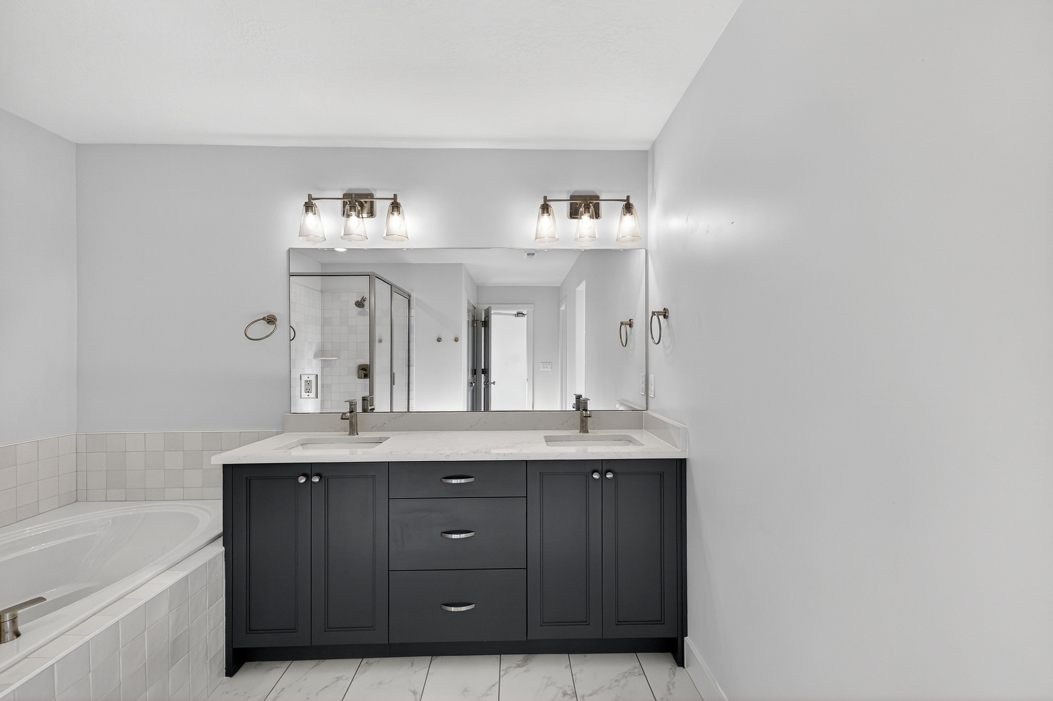 Double vanity with dark cabinetry, integrated sinks, and a light-toned countertop
