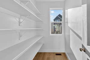 Walk in closet with light wood-style floors
