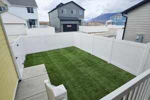 Fenced backyard with a mountain view and an attached garage