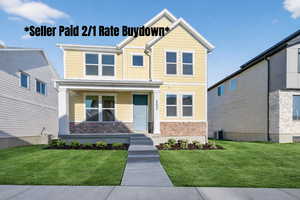 View of front of house with a front lawn, brick siding, covered porch, and board and batten siding