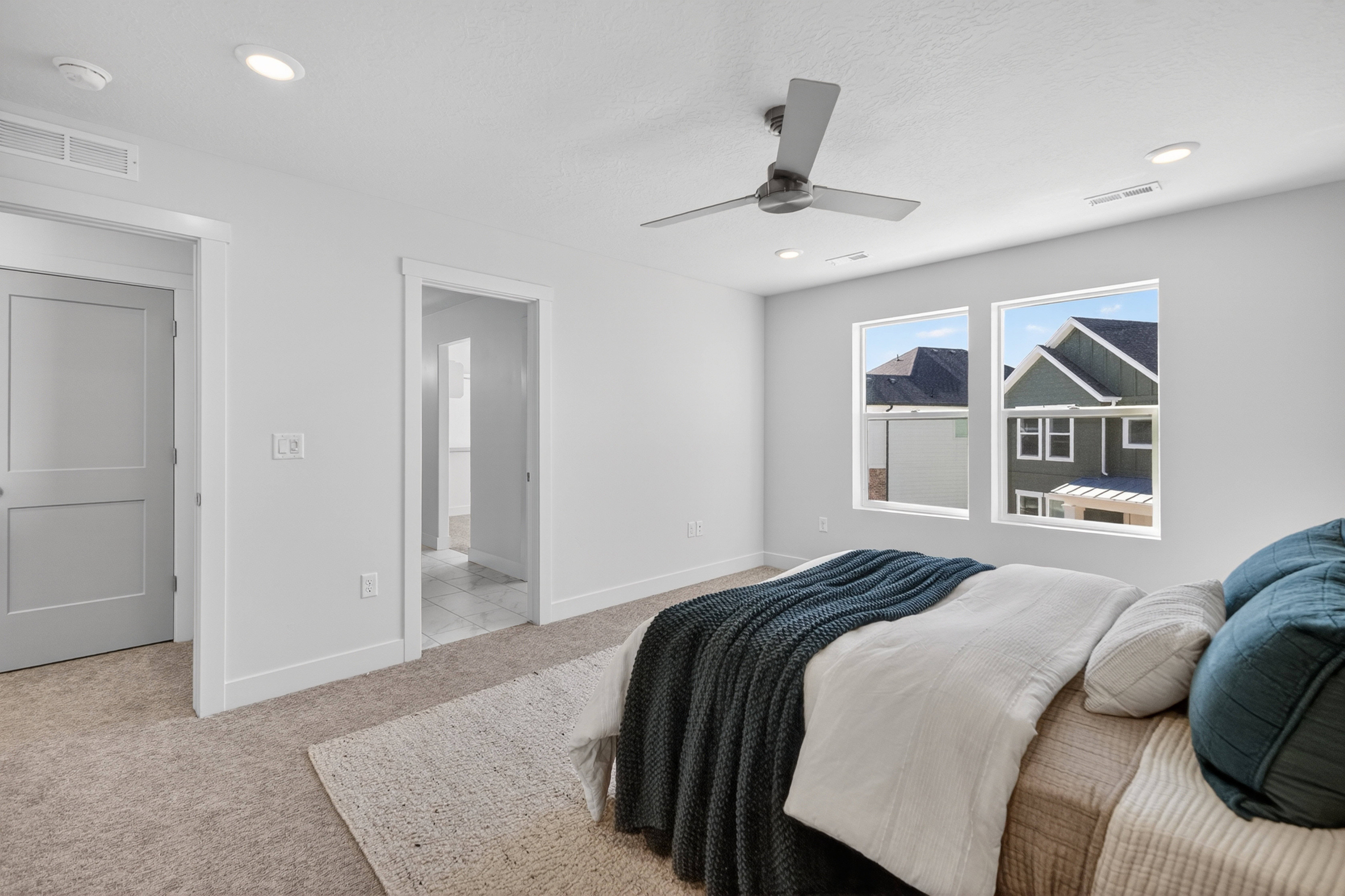 Bright room featuring two large windows, recessed lighting, and a contemporary ceiling fan