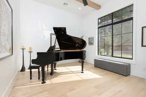 Living area featuring light wood-type flooring, recessed lighting, and beam ceiling