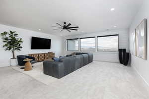 Living area featuring light colored carpet, ceiling fan, and recessed lighting