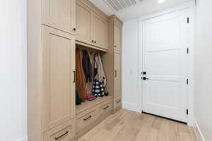 Mudroom featuring light wood-style floors and baseboards