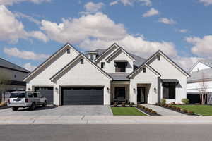 View of front of property featuring decorative driveway, an attached garage, a front yard, and brick siding
