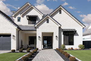 View of front of property with brick siding, driveway, and a porch
