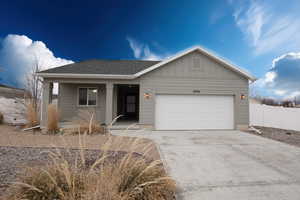 Single story home featuring a garage, driveway, roof with shingles, board and batten siding, and a porch