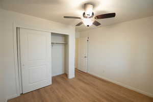 Unfurnished bedroom with a closet, a ceiling fan, and light wood finished floors