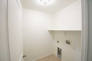 Laundry room with hookup for a washing machine, hookup for an electric dryer, and light tile patterned floors