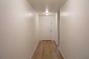 Hall with baseboards and light wood-style floors
