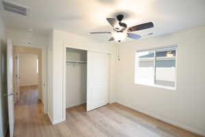 Unfurnished bedroom with light wood finished floors, a closet, and ceiling fan
