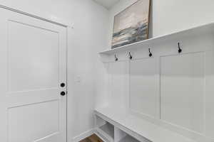 Mudroom with dark wood-style floors and baseboards