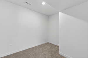 Carpeted empty room featuring baseboards and recessed lighting