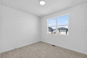Carpeted empty room featuring baseboards