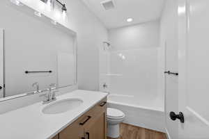 Full bathroom featuring vanity, light wood-style flooring, shower / bath combination, and recessed lighting