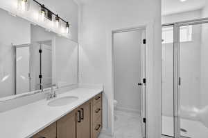 Bathroom with a stall shower, vanity, and light marble finish flooring