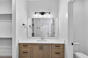 Bathroom with vanity and a walk in closet