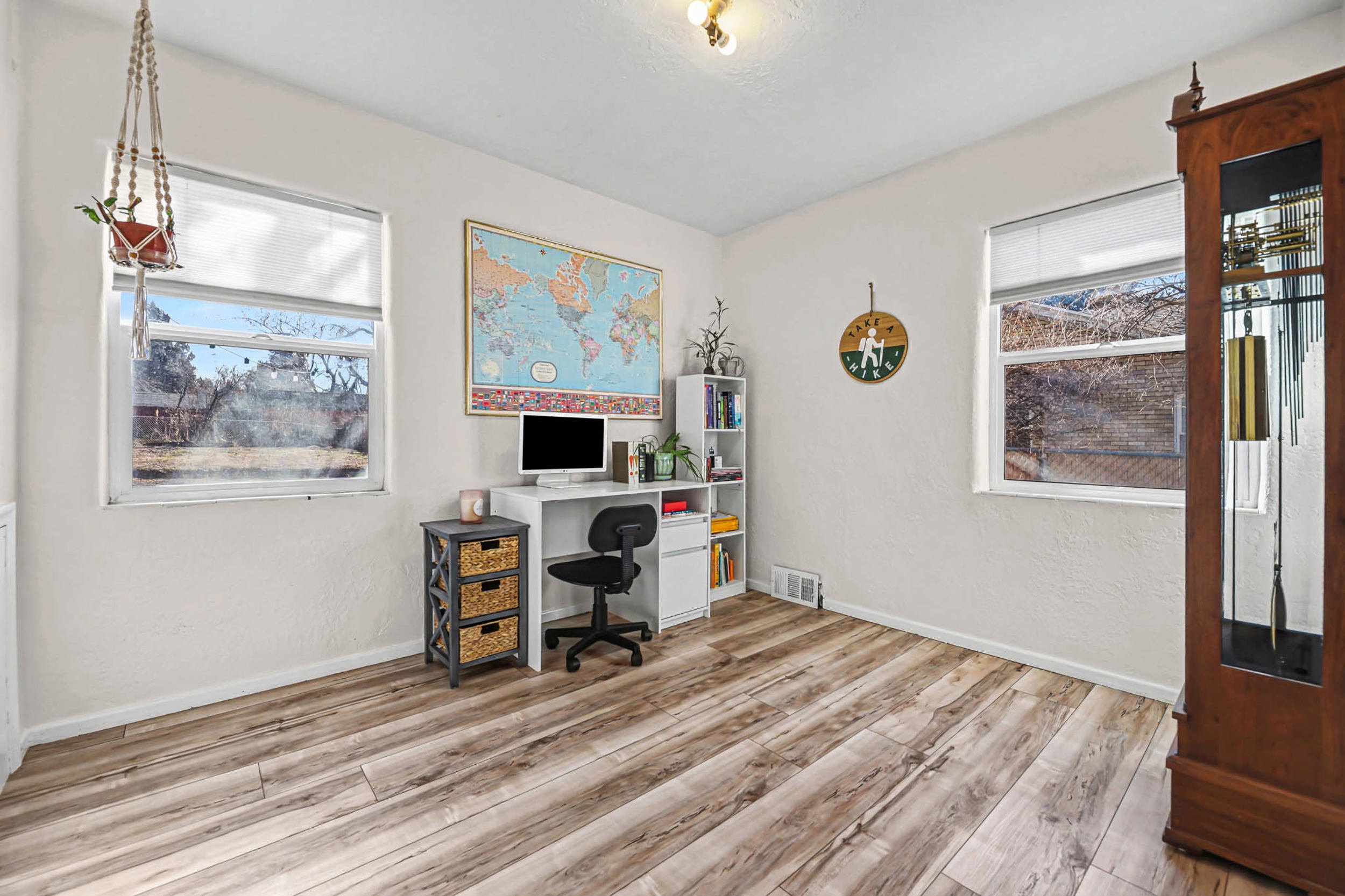 Office space with light wood-style floors and a textured wall