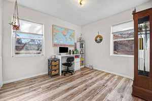 Office space with light wood-style floors and a textured wall