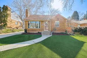 Bungalow featuring brick siding and a chimney