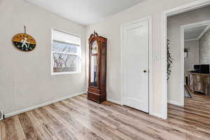 Unfurnished bedroom with light wood-style floors and a textured wall