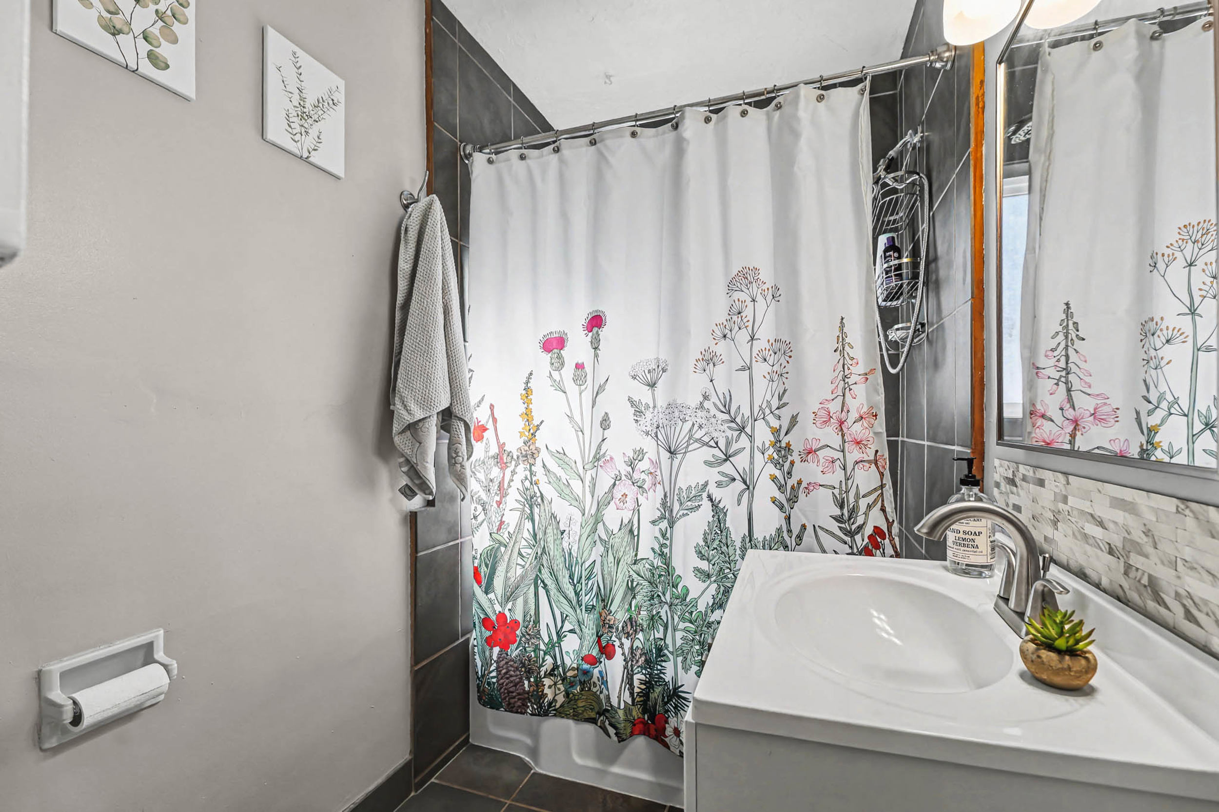 Full bath with vanity and dark tile patterned floors