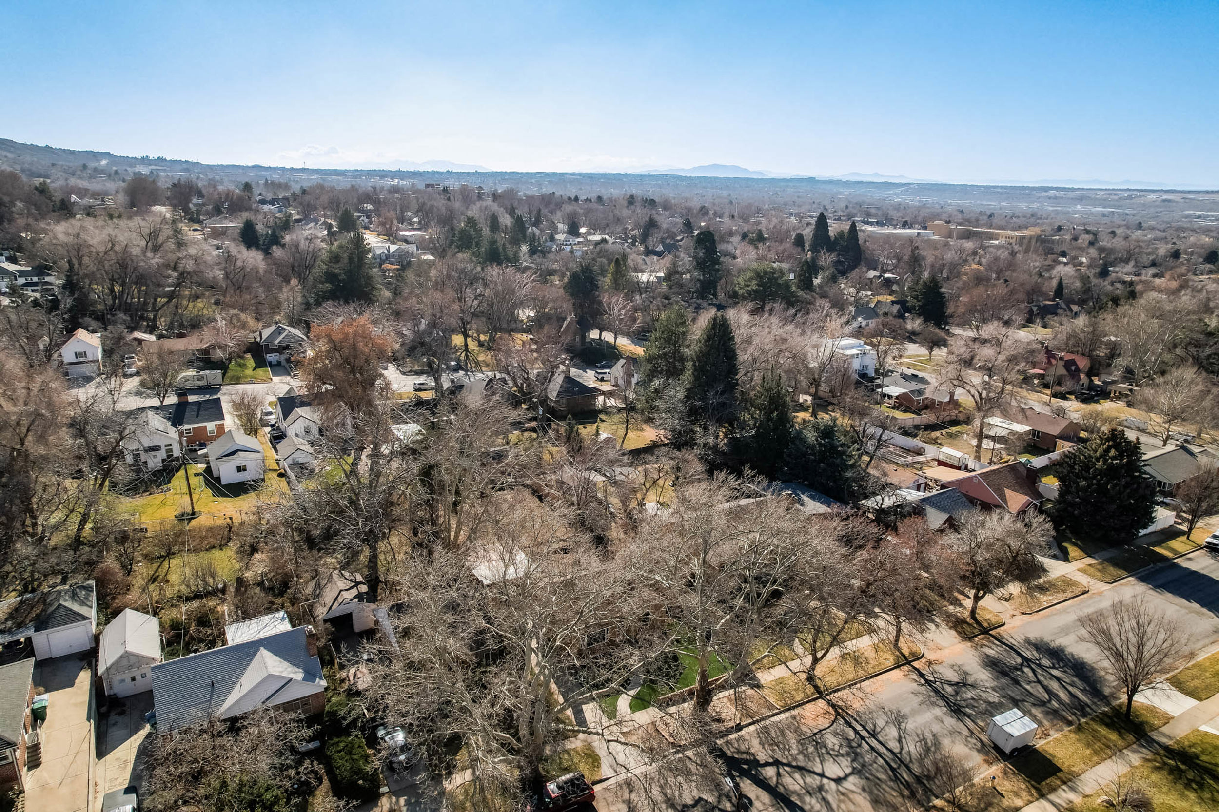 Aerial view of property and surrounding area with nearby suburban area and a mountainous background