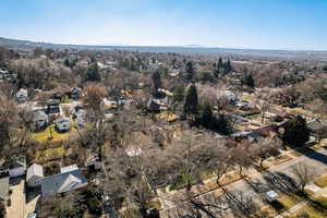 Aerial view of property and surrounding area with nearby suburban area and a mountainous background