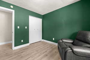 Sitting room with wood finished floors and a textured ceiling
