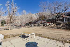 Fenced yard featuring a patio and a mountain view