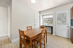 Dining area featuring a textured ceiling and wood finish floors