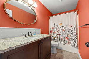 Bathroom featuring vanity, shower / tub combo with curtain, and light tile patterned floors