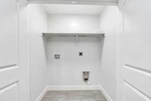 Laundry area with electric dryer hookup, washer hookup, and light wood-type flooring