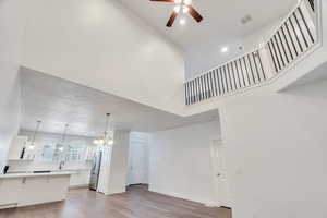 Living area featuring hanging lights, dark wood finished floors, and ceiling fan