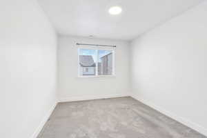 Spare room with light carpet and a textured ceiling