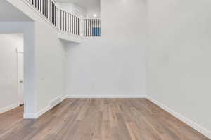 Unfurnished room featuring a high ceiling and light wood-style floors